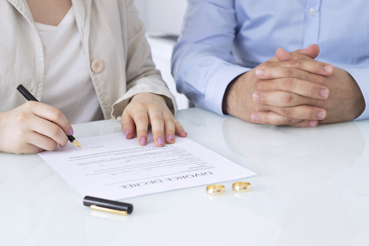 couple signing divorce papers in an office